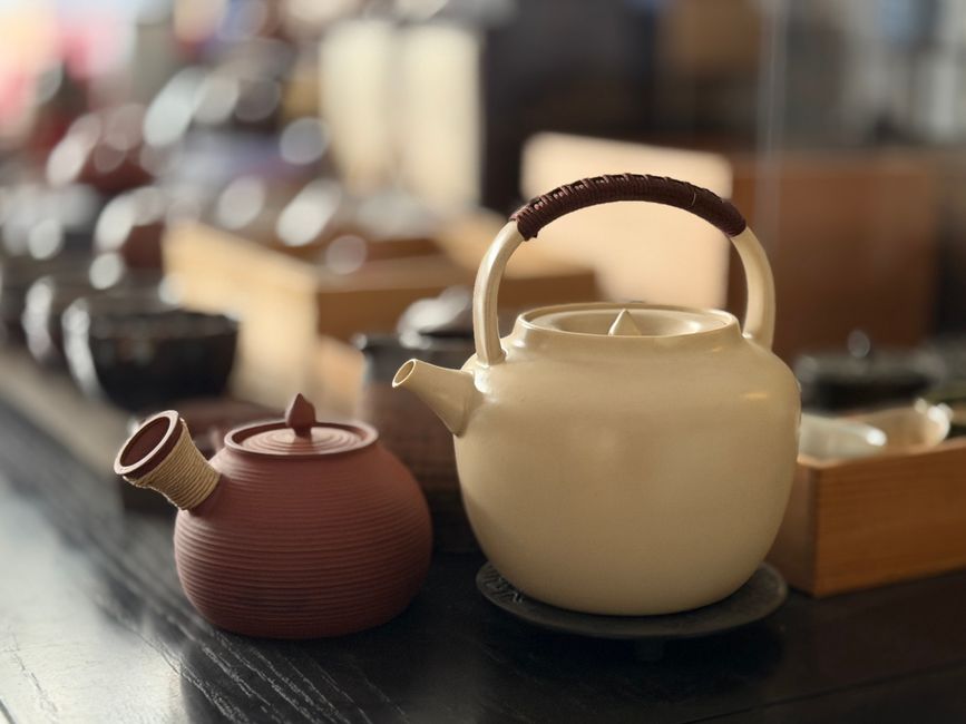 Charming ceramic teapots in a cozy tea shop setting, ideal for Asian decor or tea culture themes.